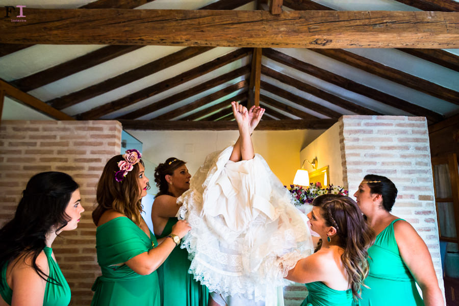 damas de honor vestidas de verde ayudando a la novia a ponerse su vestido de el tocador vintage